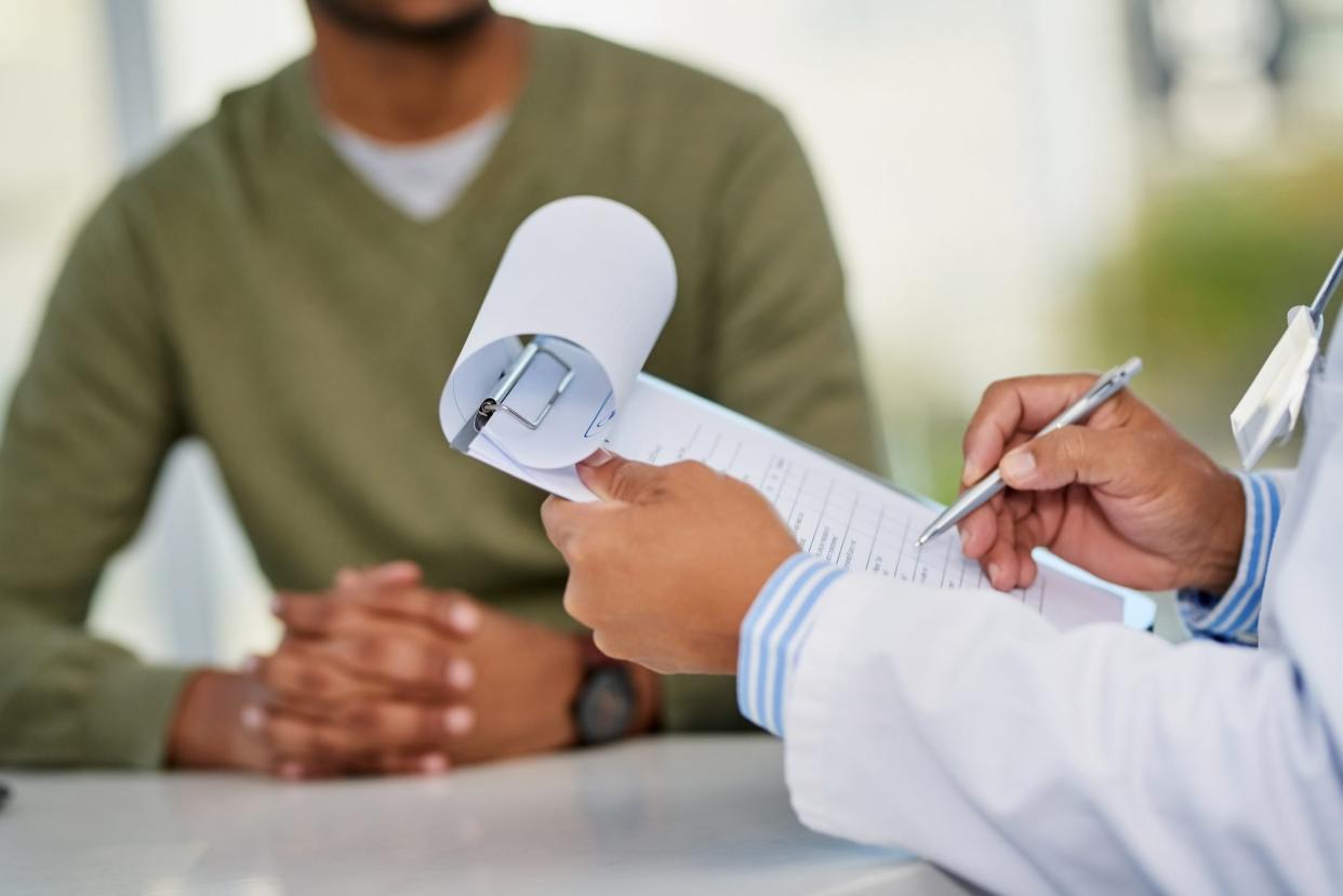 cropped shot of doctor with clipboard and patient