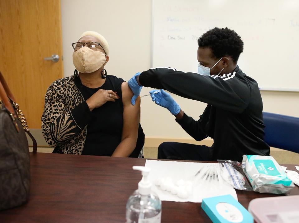 A woman gets the first dose of a Pfizer COVID-19 vaccination from a surgical resident at UF Health during a vaccination session at Mt. Moriah Missionary Baptist Church in Gainesville.