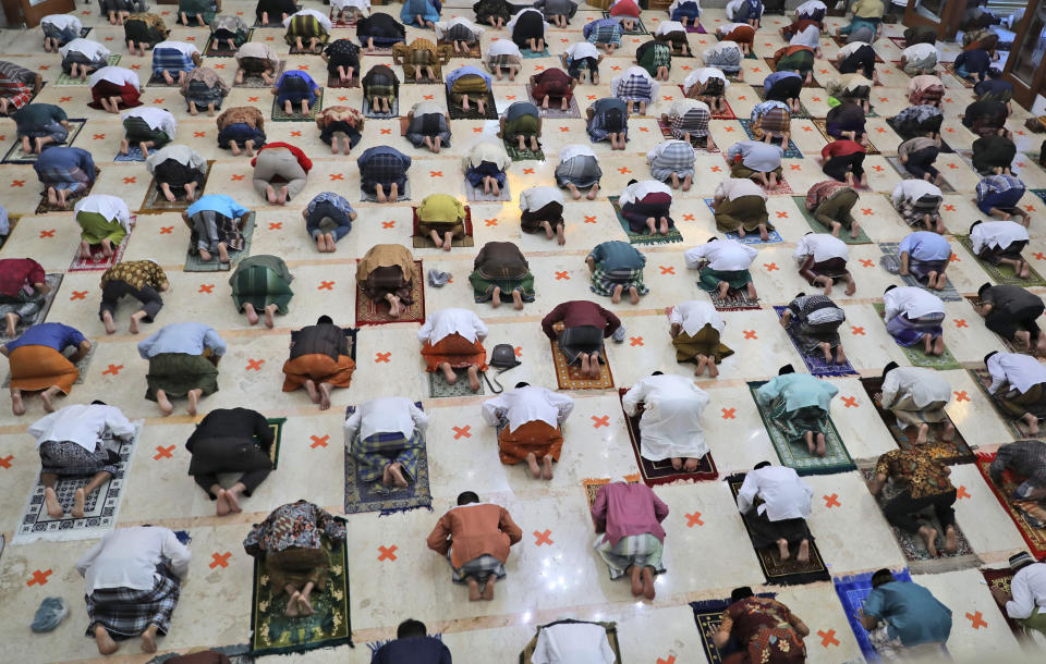 Indonesian Muslims pray spaced apart as they practice social distancing to curb the spread of the new coronavirus during an Eid al-Fitr prayer marking the end of the holy fasting month of Ramadan in Sidoarjo, East Java, Indonesia, Sunday, May 24, 2020. Millions of people in the world's largest Muslim nation are marking a muted and gloomy religious festival of Eid al-Fitr, the end of the fasting month of Ramadan _ a usually joyous three-day celebration that has been significantly toned down as coronavirus cases soar. (AP Photo/Trisnadi)