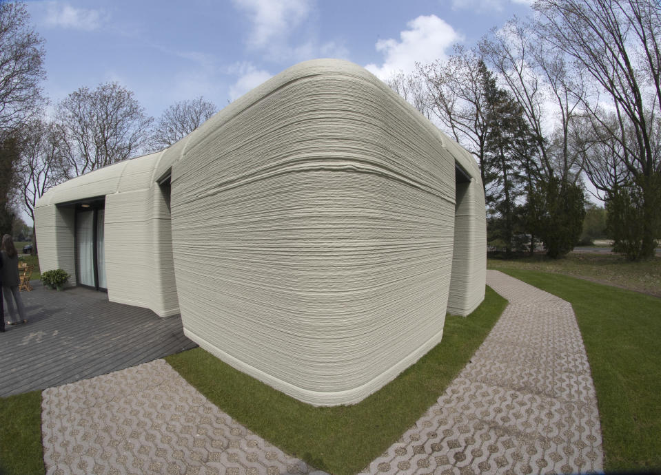 Exterior view showing the printer layers of the 3D-printed 94-square meters (1,011-square feet) two-bedroom bungalow resembling a boulder with windows in Eindhoven, Netherlands, Friday, April 30, 2021. The fluid, curving lines of its gray walls look natural. But they are actually at the cutting edge of housing construction in the Netherlands and around the world. They were 3D printed at a nearby factory. (AP Photo/Peter Dejong)