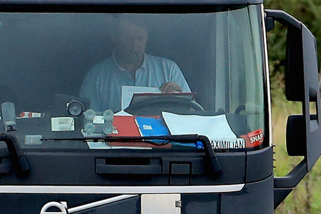 A lorry driver reads paperwork as he drives along the M20 near Ashford, Kent.