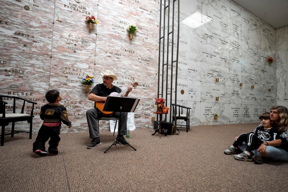 Juan Dies, of Chicago, sings murder ballads inside a mausoleum at Green Lawn Cemetery while Gustavo Cisneros-Labra watches at a Day of the Dead festival Saturday in Columbus.