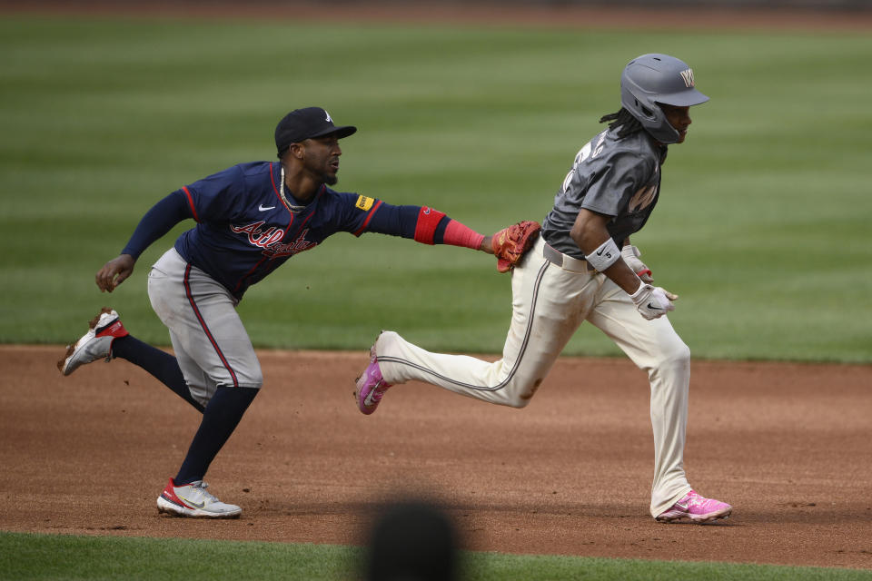 Washington Nationals' CJ Abrams, right, is tagged out by Atlanta Braves second baseman Ozzie Albies, left, in a rundown during the second inning of a baseball game, Saturday, June 8, 2024, in Washington. (AP Photo/Nick Wass)