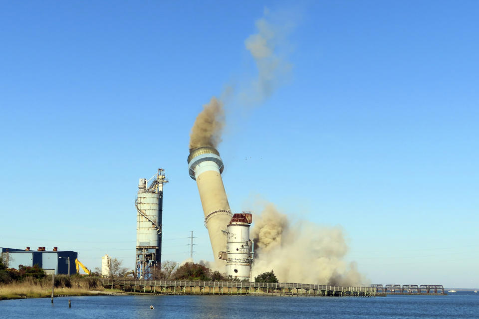 The smokestack at the former B.L. England power plant in Upper Township, N.J., is toppled during a control demolition, Thursday, Oct. 26, 2023. The site will be redeveloped as a mixed use residential and commercial project, and a nearby electrical substation will be used to connect New Jersey's soon-to-come offshore wind farms with the electrical grid. (AP Photo/Wayne Parry)