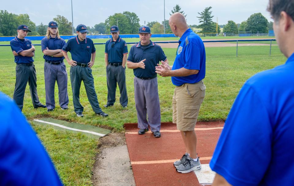 Umpires confer with clinic instructor and veteran umpire Dave Owen during a clinic Saturday, Aug. 20, 2022 at Illinois Central College in East Peoria.