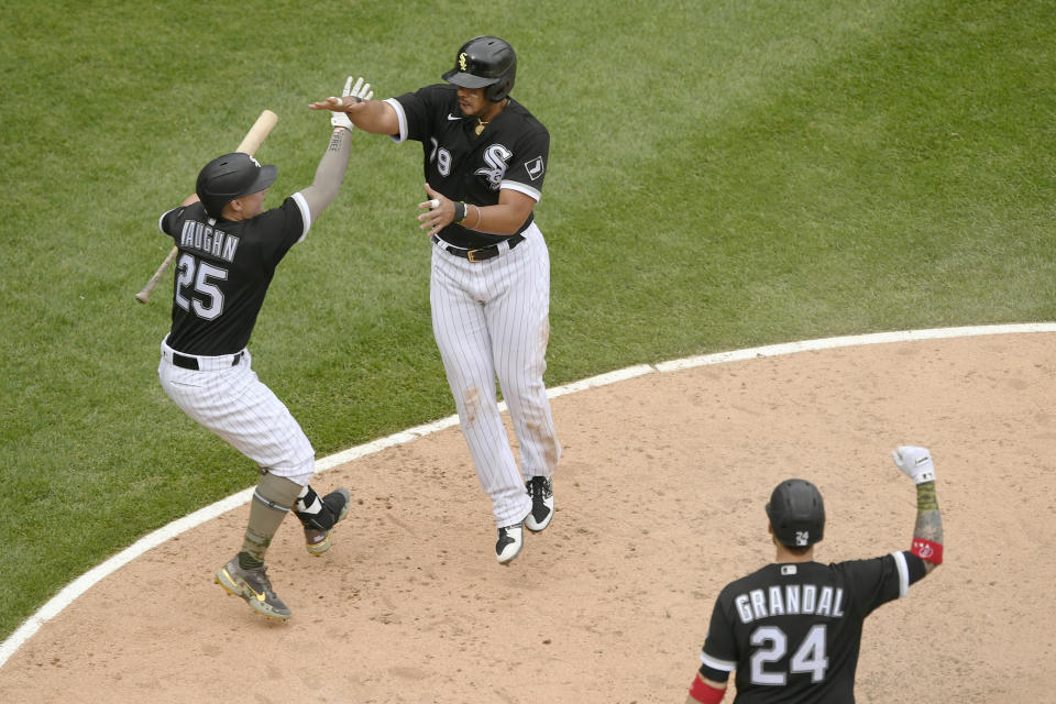 Chicago White Sox's Jose Abreu (79) celebrates with teammate Andrew Vaughn (25) after sliding into home plate safely on a wild pitch to defeat the Kansas City Royals in a baseball game Sunday, May 16, 2021, in Chicago. (AP Photo/Paul Beaty)