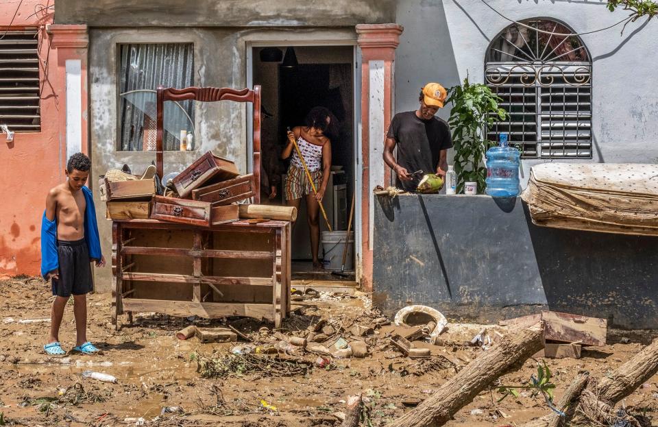 Neighbors work to recover their belongings after the flooding caused by Hurricane Fiona in the Los Sotos neighborhood of Higüey, Dominican Republic