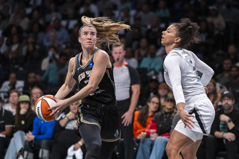 New York Liberty guard Sabrina Ionescu, left, is defended by Las Vegas Aces forward Alysha Clark, right, during the first half of a WNBA basketball second-round playoff game, Sunday, Sept. 29, 2024, in New York. (AP Photo/Corey Sipkin)