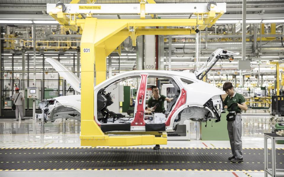 Employees assemble a Jaguar E-Pace compact sport utility vehicle (SUV) on the production line - Qilai Shen /Bloomberg