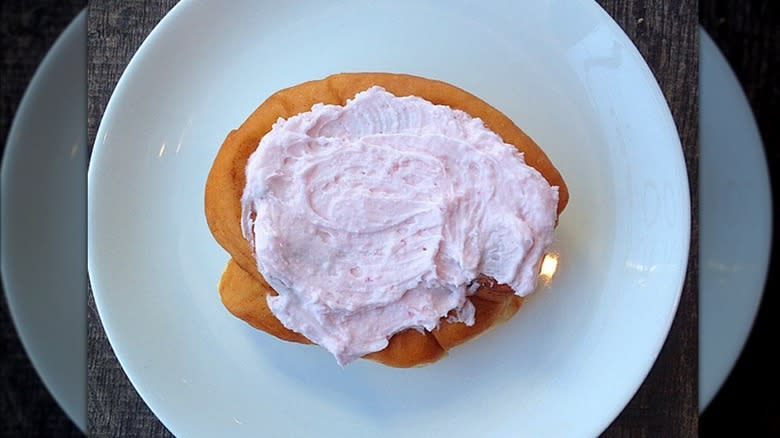 Persian donut with pink frosting on plate