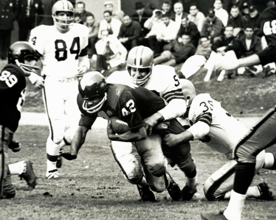 Browns linebacker Vince Costello (50) tackles Washington receiver Charley Taylor, Nov. 8, 1964, in Cleveland. The Browns won 34-24.