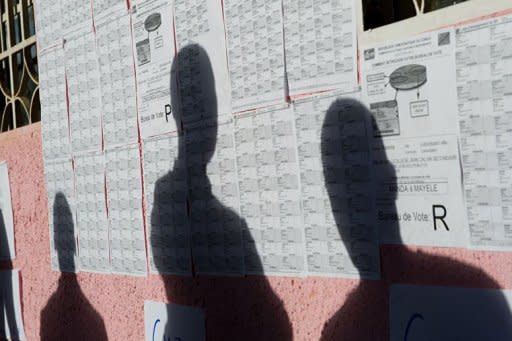 A Congolese man checks his name against the list of registered voters at the Jean Calvin College voting centre in Lubumbashi. Officials guaranteed Sunday the DR Congo's elections would go ahead on time despite rising tensions as opposition leader Etienne Tshisekedi called, then cancelled, a rally in defiance of a ban imposed after deadly unrest