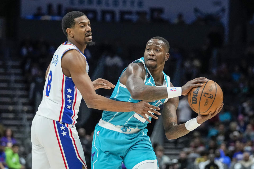 Charlotte Hornets guard Terry Rozier, right, looks to pass around the defense of Philadelphia 76ers guard De'Anthony Melton, left, during the first half of an NBA basketball game Wednesday, Nov. 23, 2022, in Charlotte, N.C. (AP Photo/Rusty Jones)