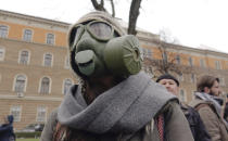 A person wearing a gas mask takes part in a protest against air pollution, in Sarajevo, Bosnia, Monday, Jan. 20, 2020. Dozens of people, some wearing face masks, gathered for a protest because of dangerously high levels of air pollution in the past weeks in the Bosnian capital after measurements in the past weeks have shown that levels of damaging airborne particles have exceeded European Union's safety norms by several times.(AP Photo/Eldar Emric)