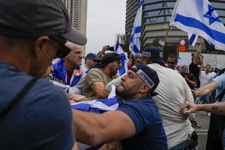 Israelis protest against plans by Prime Minister Benjamin Netanyahu's government to overhaul the judicial system scuffle with police in Tel Aviv, Israel, Thursday, March 23, 2023. (AP Photo/Ohad Zwigenberg)