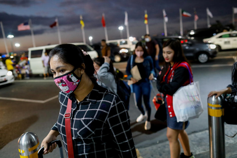 Overseas Filipino Workers (OFW) wearing protective masks walk towards the departure entrance of the Ninoy Aquino International Airport in Pasay City, Metro Manila, Philippines, February 18, 2020. REUTERS/Eloisa Lopez