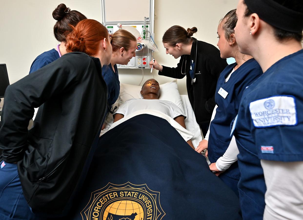 Nursing students at Worcester State University work with a patient simulator mannequin.
