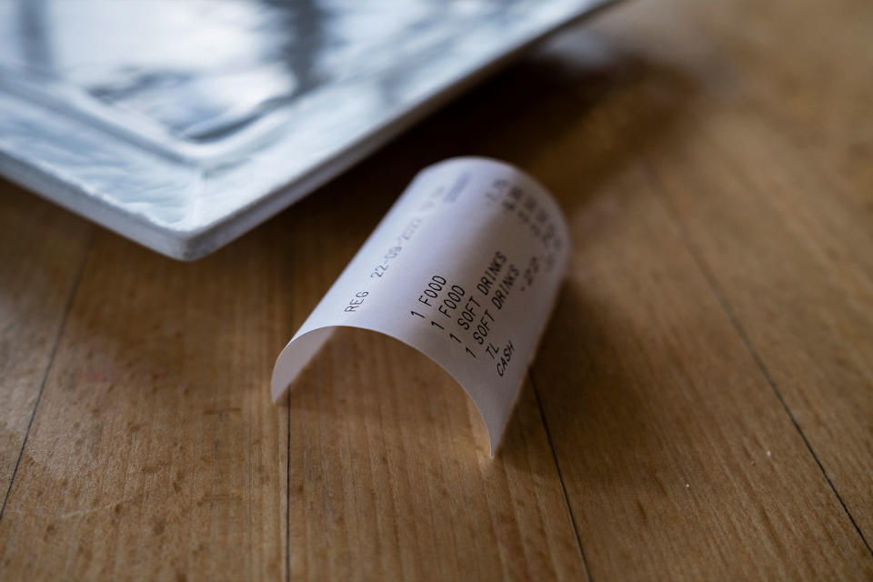 A receipt for food and drink on a table in a restaurant cafe. Loop Images/Gordon Scammell/Universal Images Group via Getty Images