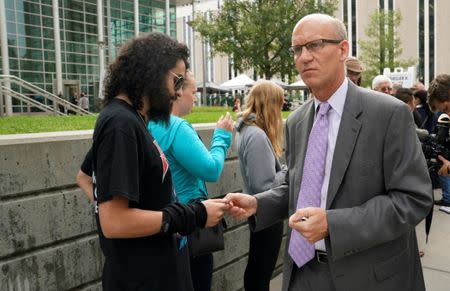 A Taylor Swift fan gets a number from Jeffrey Colwell (R), Clerk of Court, that will allow him into Denver Federal Court where the Taylor Swift groping trial jury selection is to resume in Denver, U.S., August 8, 2017. REUTERS/Rick Wilking