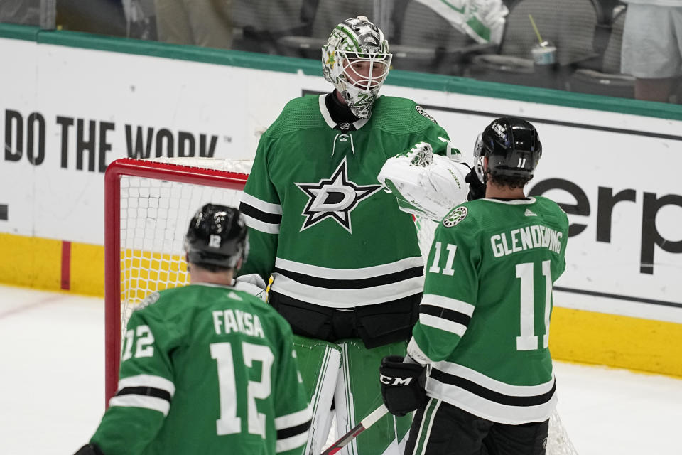 Dallas Stars goaltender Jake Oettinger, center, and teammates Radek Faksa (12) and Luke Glendening (11) celebrate the team's 4-0 win against the Minnesota Wild in Game 5 of an NHL hockey Stanley Cup first-round playoff series, Tuesday, April 25, 2023, in Dallas. (AP Photo/Tony Gutierrez)