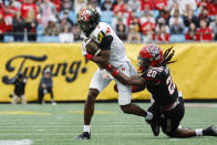 Maryland wide receiver Dontay Demus Jr., left, fights for yardage after a catch as North Carolina State safety Sean Brown holds on during the first half of the Duke's Mayo Bowl NCAA college football game in Charlotte, N.C., Friday, Dec. 30, 2022. (AP Photo/Nell Redmond)