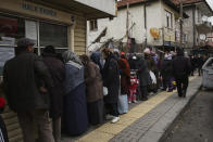 People buy bread in an Ankara Municipality's bread kiosk in Mamak neighbourhood, in Ankara's suburb, Turkey, Wednesday, Dec. 1, 2021. Turkey’s beleaguered currency has been plunging to all-time lows against the U.S. dollar and the euro in recent months as President Recep Tayyip Erdogan presses ahead with a widely criticized effort to cut interest rates despite surging consumer prices. (AP Photo/Burhan Ozbilici)