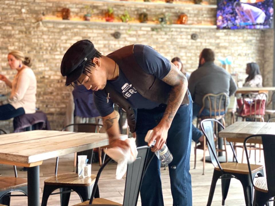 A Haberdish employee sanitizes a chair after a guest’s departure to ensure optimal health and safety.