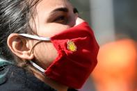Protester wears a protective face mask during a demonstration outside of the Shell headquarters, in The Hague