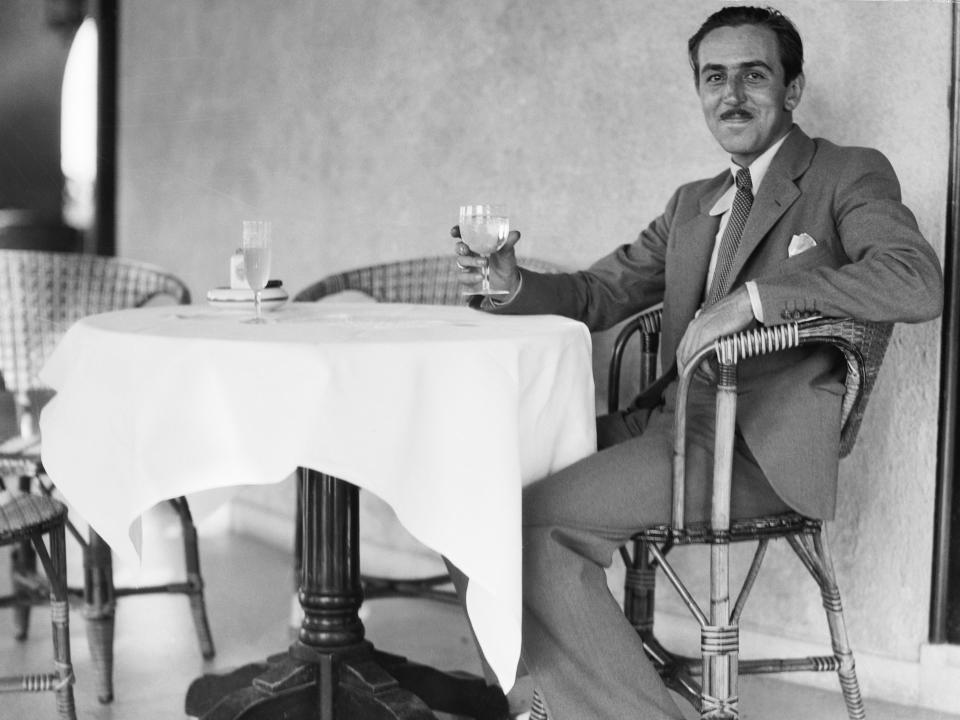 A young walt disney sitting in a chair at a table