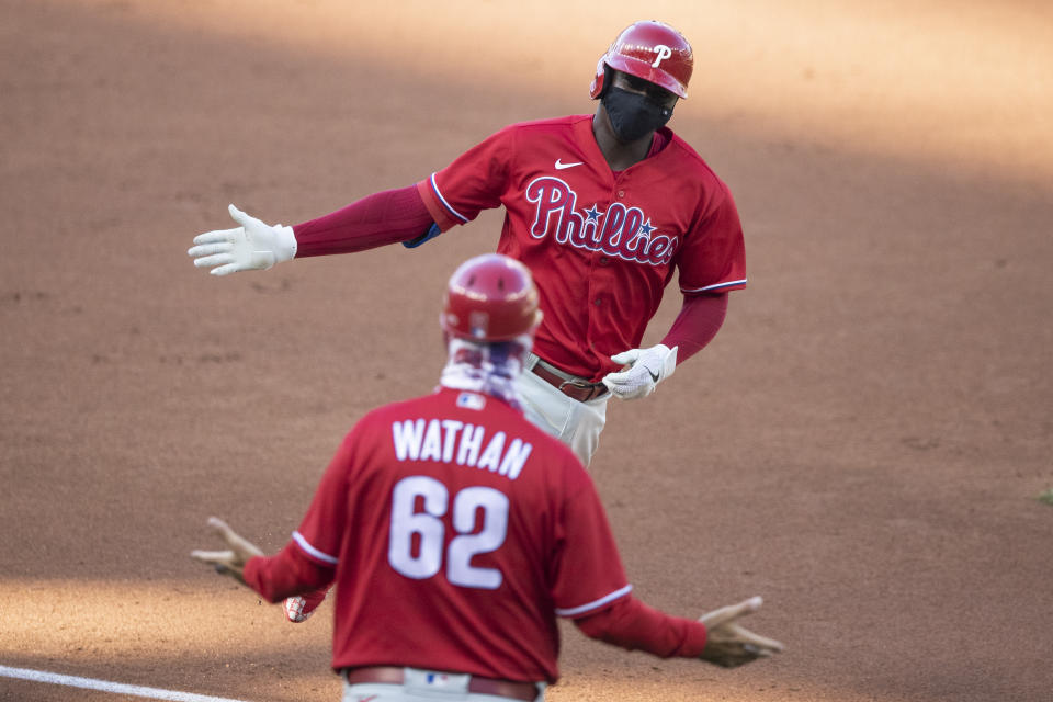 Philadelphia Phillies' Didi Gregorius celebrates with third base coach Dusty Wathan as he rounds the bases for his three-run homer during the first inning of an exhibition baseball game against the Washington Nationals at Nationals Park, Saturday, July 18, 2020, in Washington. (AP Photo/Alex Brandon)