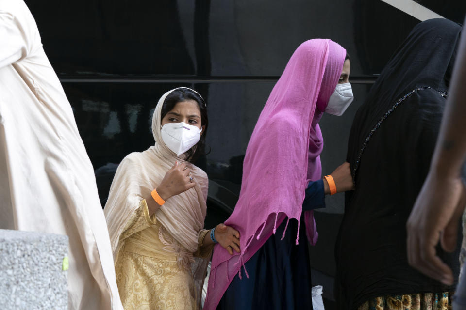 People evacuated from Kabul, Afghanistan, wait to board a bus after they arrived at Washington Dulles International Airport, in Chantilly, Va., on Monday, Aug. 30, 2021. (AP Photo/Jose Luis Magana)