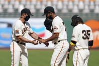 San Francisco Giants relief pitcher Jarlin García hands the ball to manager Gabe Kapler, left, and leaves the game in the seventh inning of a baseball game against the San Diego Padres Sunday, Sept. 27, 2020, in San Francisco. At right is Giants shortstop Brandon Crawford (35). (AP Photo/Eric Risberg)