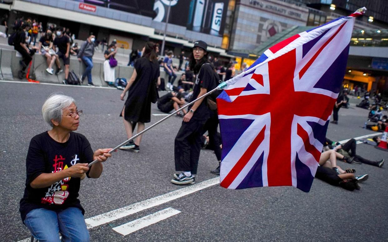 Alexandra Wong, 63, holds up a Union Flag during a demonstration demanding Hong Kong's leaders step down and withdraw an extradition bill - REUTERS