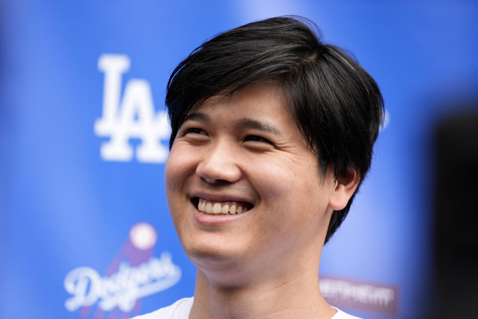 Los Angeles Dodgers' Shohei Ohtani smiles while talking to the media at Dodger Stadium during the DodgerFest baseball event Saturday, Feb. 3, 2024, in Los Angeles Calif. (AP Photo/Richard Vogel)
