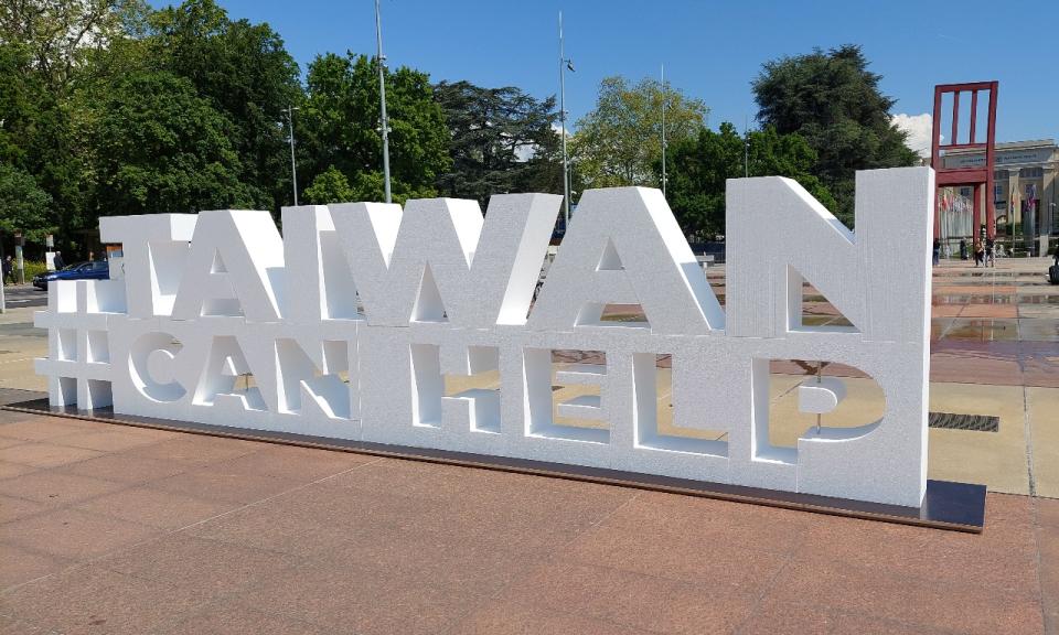 日內瓦「三腳椅」廣場前「TAIWAN CAN HELP」推案文宣。(劉品希 攝)