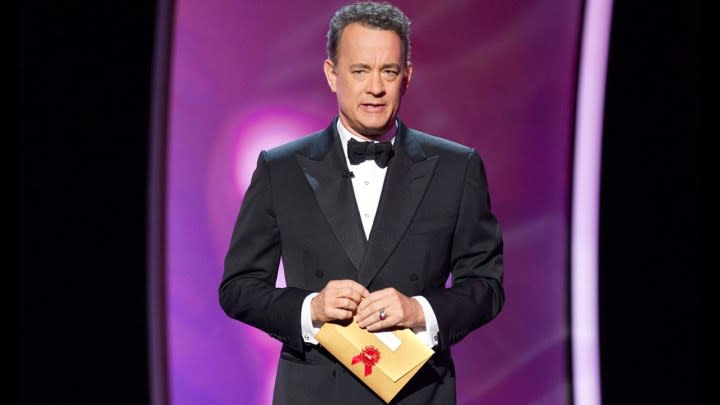 Tom Hanks holding an envelope at the Academy Awards.