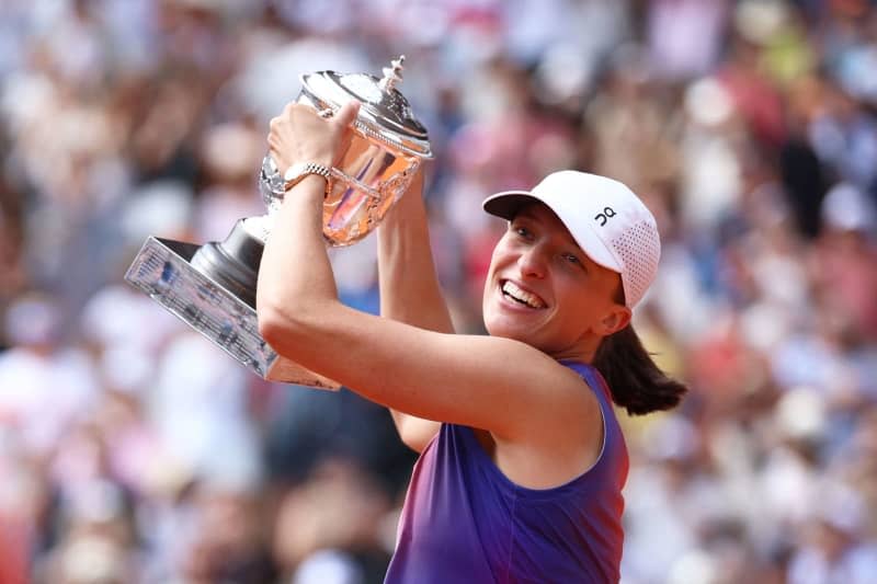 Polish tennis player Iga Swiatek celebrates with the trophy after winning against Italy's Jasmine Paolini at the end of their Women's Singles Final tennis match on Court Philippe-Chatrier on Day 14 of the French Open tennis tournament at the Roland Garros Complex. Emmanuel Dunand/AFP/dpa