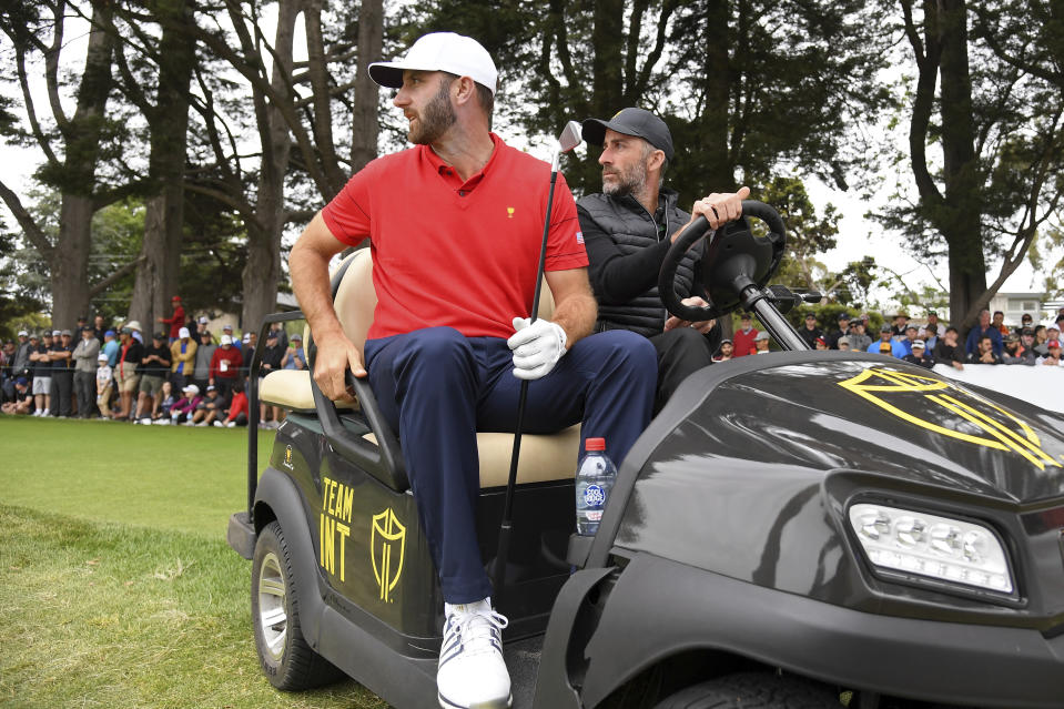 FILE - U.S. team player Dustin Johnson, left, hitches a ride with Australian golfer Geoff Ogilvy during his singles match at the Presidents Cup golf tournament at Royal Melbourne Golf Club in Melbourne, Sunday, Dec. 15, 2019. Ogilvy at age 45 wants to return to a full schedule on the PGA Tour after a four-year absence. (AP Photo/Andy Brownbill, File)