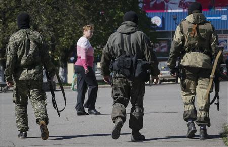 Pro-Russian armed men walk down a street in central Slaviansk April 25, 2014. REUTERS/Gleb Garanich