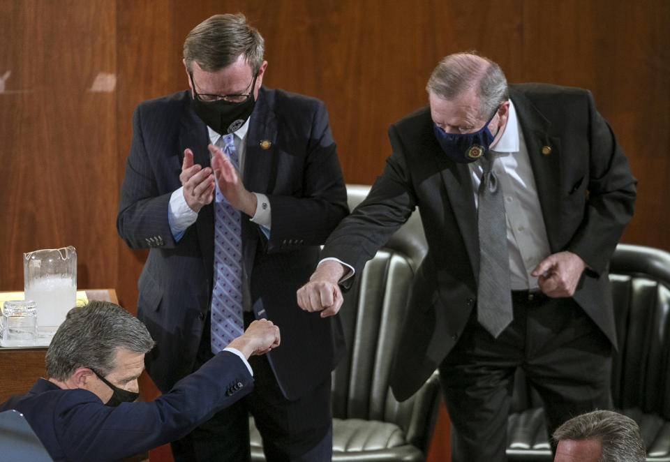 Sen. Phil Berger, right, fist bumps North Carolina Gov. Roy Cooper after Cooper delivered his State of the State address before a joint session of the North Carolina House and Senate, Monday, April 26, 2021, in Raleigh, N.C. (Robert Willett/The News & Observer via AP)