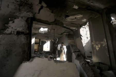 Houthi militants stand in the house of Houthi leader Yahya Aiydh, after Saudi-led air strikes destroyed it in Yemen's capital Sanaa September 8, 2015. REUTERS/Khaled Abdullah