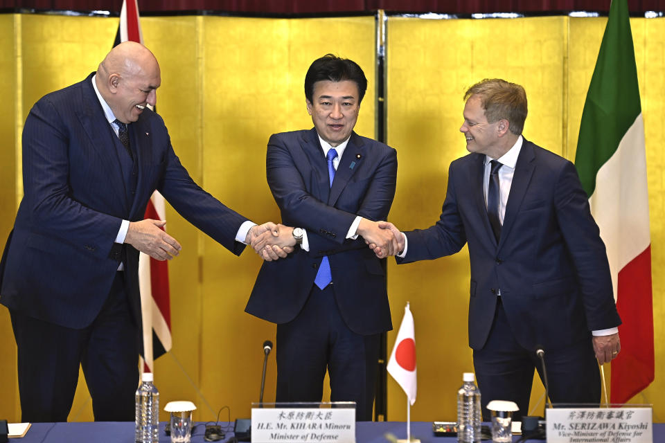 Britain's Defense Minister Grant Shapps, right, Italy's Defense Minister Guido Crosetto, left, and Japanese Defense Minister Minoru Kihara, center, shake hands prior a trilateral meeting at the defense ministry Thursday, Dec. 14, 2023, in Tokyo, Japan. (David Mareuil/Pool Photo via AP)