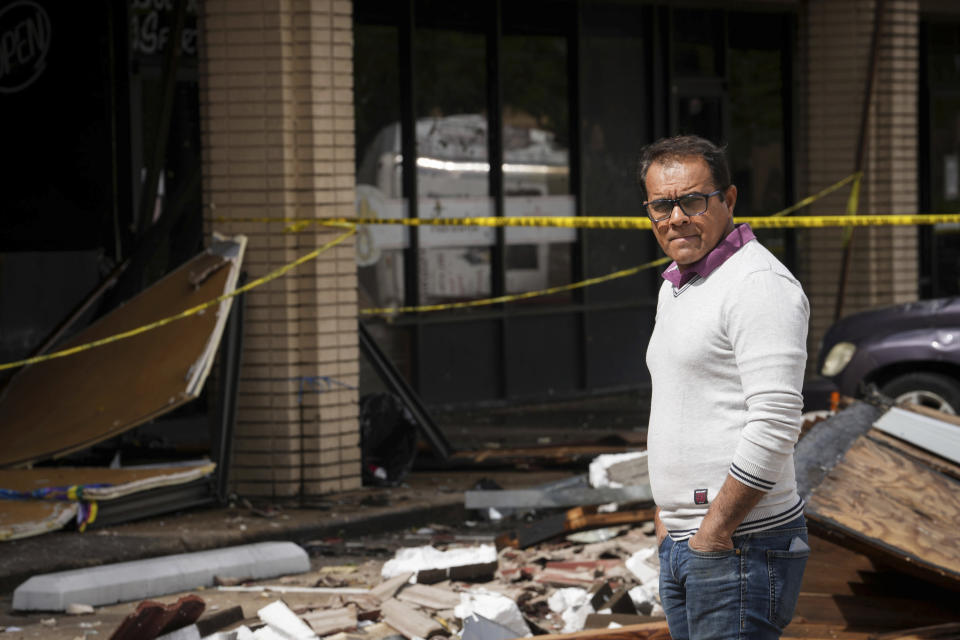 Ramesh Dadewal surveys damage from a tornado that damaged several businesses Wednesday, April 10, 2024, in Katy, Texas. He came from India to visit a storeowner who sells his furniture. (Jon Shapley/Houston Chronicle via AP)