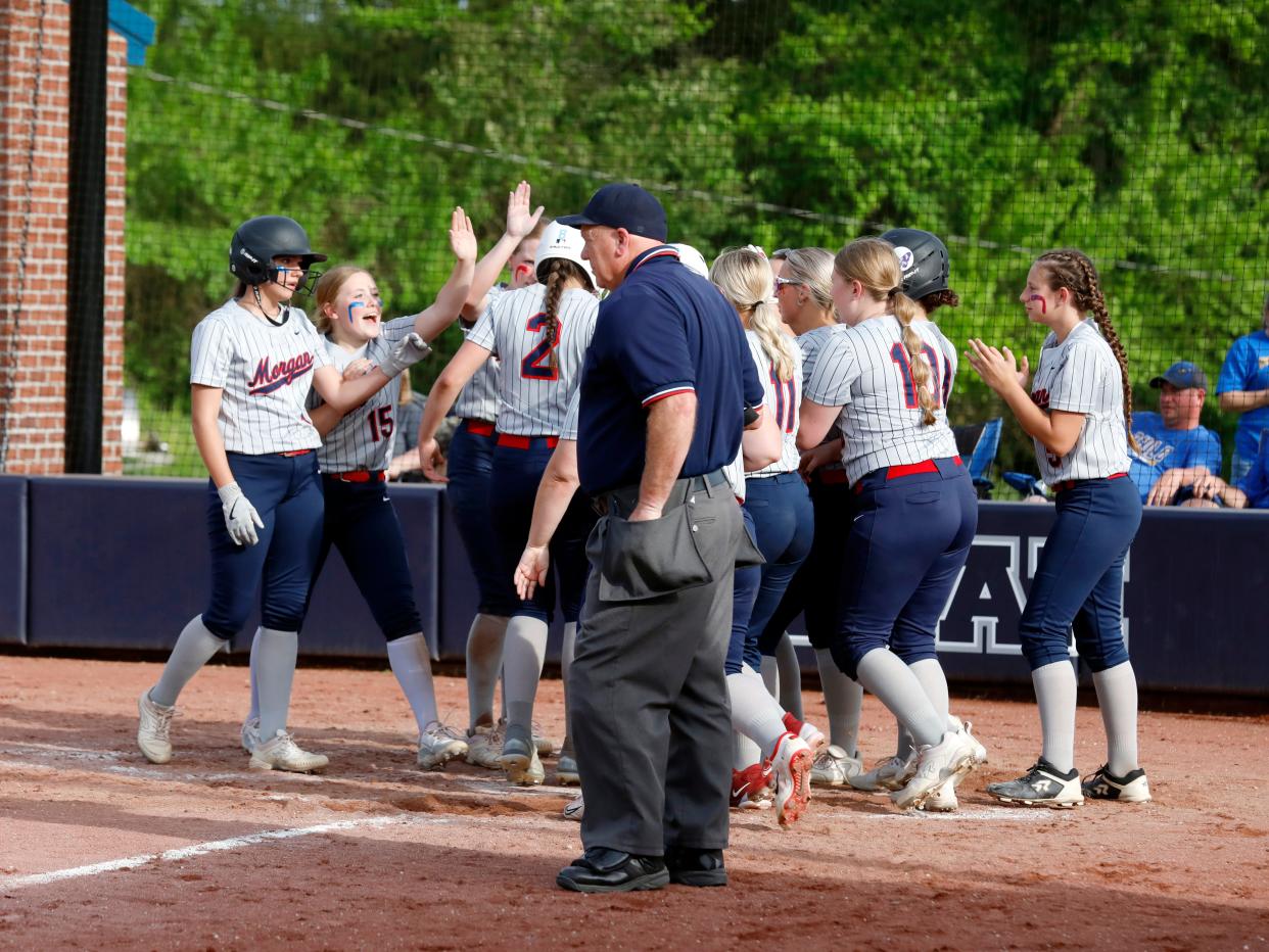 Allia Rush is congratulated by teammates at home plate after a fourth-inning home runs during Morgan's 14-0 mercy of visiting Philo in a Division II sectional game on Wednesday in McConnelsville.