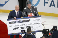 Edmonton Oilers forward Connor McDavid (97) accepts the Pacific Division team's check after they defeated the Atlantic Division 5-4 in the NHL All-Star final game Saturday, Jan. 25, 2020, in St. Louis. (AP Photo/Scott Kane)