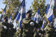 Greek soldiers hold Greek flags during a military parade at the northern port city of Thessaloniki, Greece, Thursday, Oct. 28, 2021 .The parade is held to celebrate Greece's refusal to align itself with a belligerent fascist Italy in 1940 and instead fight a much stronger opponent, a decision which dragged it into World War II and eventually led to a brutal occupation by Nazi Germany. (AP Photo/Giannis Papanikos)