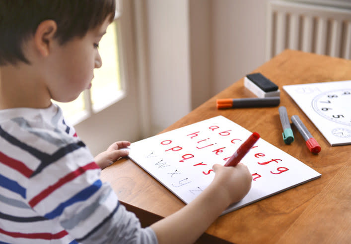 kid practicing writing his letters