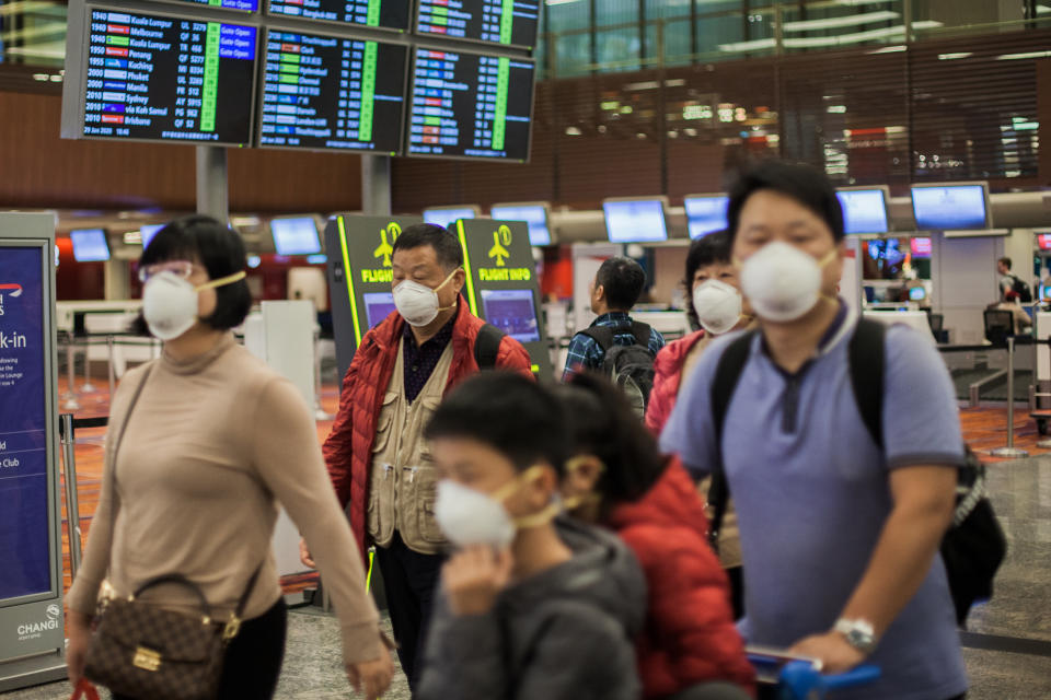 MRT, SINGAPORE - 2020/01/29: A family seen wearing protective n95 masks as they walk around Changi Airport in Singapore. Many people have started wearing protective masks in many places around the world due to the fear of Wuhan coronovirus outbreak. Ten people tested positive for the Wuhan coronavirus in Singapore as of 29th January 2020- as reported by the country's Ministry of Health (MOH). (Photo by Maverick Asio/SOPA Images/LightRocket via Getty Images)