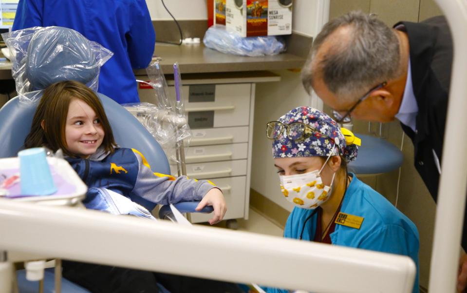 Dr. Ron Johnson, right, visits with a patient Friday, Feb. 2 during the 21st annual Give Kids a Smile Day free dental clinic at the Health and Human Performance Center at San Juan College in Farmington.