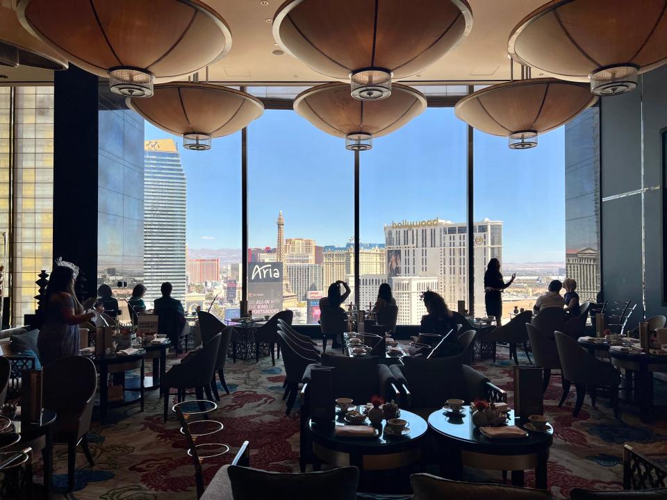 A lounge area with seating and people and views of Las Vegas.